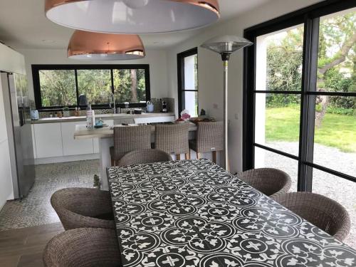 une salle à manger avec une table, des chaises et des fenêtres dans l'établissement Villa EDEN Grimaud - Golfe de Saint Tropez, à Grimaud