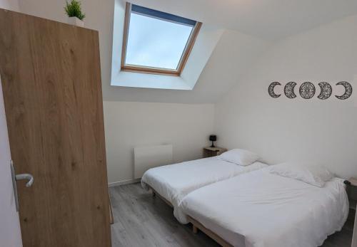 2 Betten in einem weißen Zimmer mit Fenster in der Unterkunft Grande maison avec extérieur, jacuzzi et billard in Vierzon