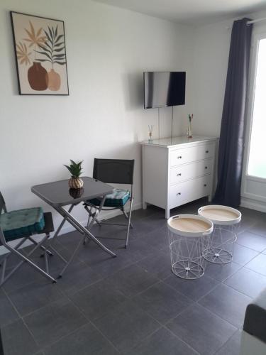 - un salon avec une table, des chaises et une commode dans l'établissement Studio Balcon Narbonne Centre, à Narbonne