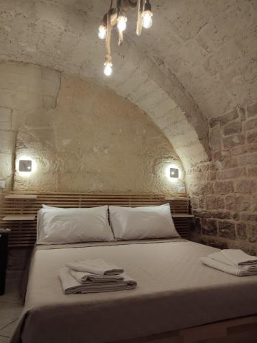 a bedroom with a bed in a stone room at La Cas d Zii la Giulia in Bari
