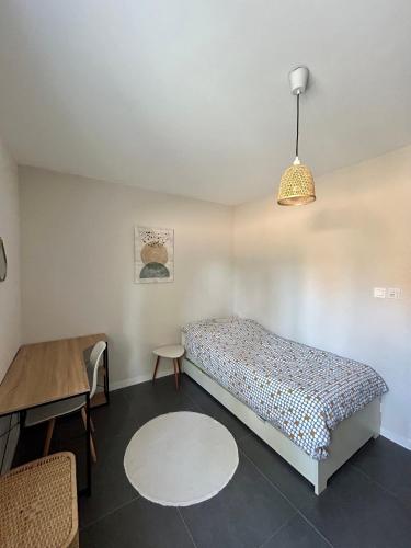 une chambre avec un lit, une table et une lampe dans l'établissement Bas de villa avec piscine privé - calme, à La Seyne-sur-Mer