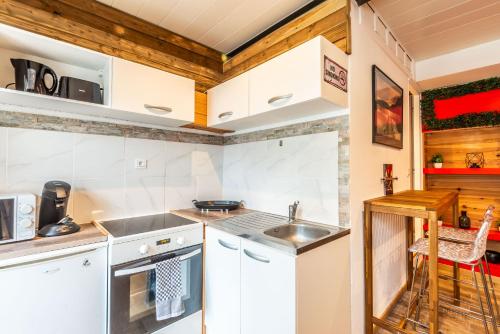 une cuisine avec des armoires blanches et un évier dans l'établissement Charme entre plage et montagne, à Sciez