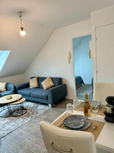 un salon avec un canapé bleu et une table dans l'établissement Superbe Appartement Très Calme et Confortable, à Reims