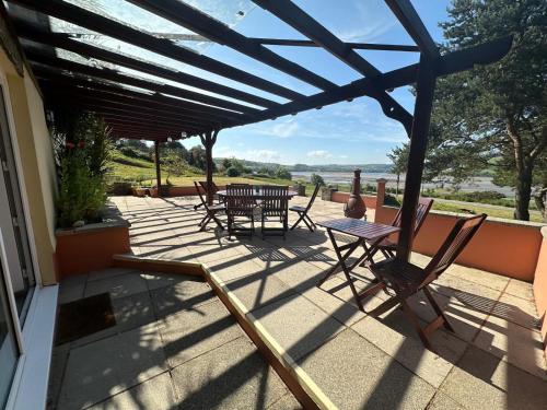 a patio with a table and chairs on a house at Sheko Annex in Cardigan