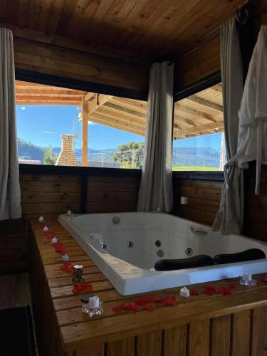 a large bath tub in a room with windows at Chalés Refúgio Ohana in Urubici