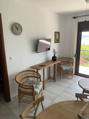 a living room with a television and a table and chairs at apartment by the sea in Neos Marmaras