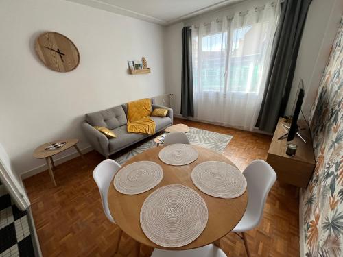 un salon avec une table et un canapé dans l'établissement Appartement Vichy Centre, à Vichy