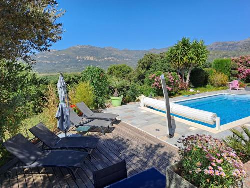 une piscine avec des chaises et un parasol dans l'établissement Villa Cutalello coté montagne Calenzana, à Calenzana