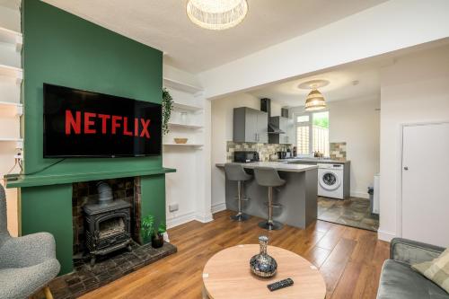 a living room with a fireplace and a kitchen at Vale House By EDEN Accommodation - 2 Bedroom Whole House, Sleeps 4 - NEWLY RENOVATED in Kettering