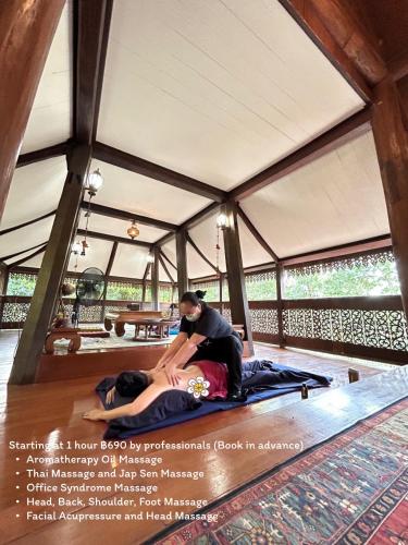 a man and a woman sitting on a bed in a tent at Ban MaeBo Local Stay in Ban Nong Han