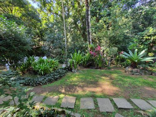 a garden with plants and trees and a walkway at Pousada Cachoeira in Abraão