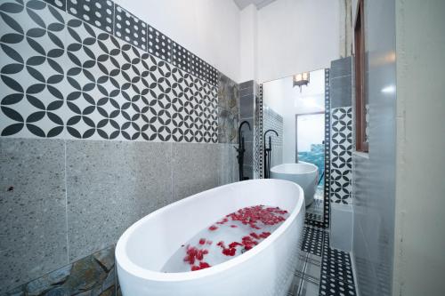 胡志明市的住宿－Secret Elm Hotel，一间位于客房内的带大型白色浴缸的浴室