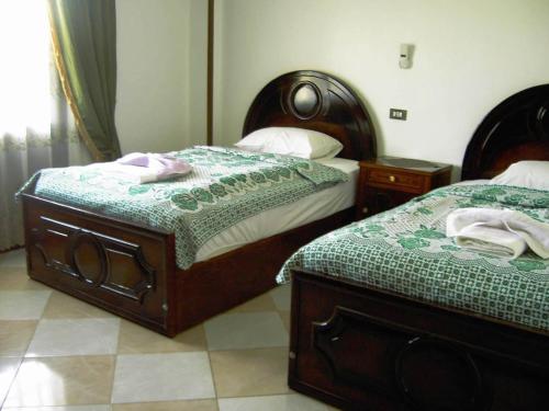 a bedroom with two beds and two night stands at Nile Dream Apartments in Luxor