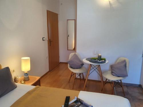 a bedroom with a bed and a table and chairs at Apartments LEON 1 in Rab