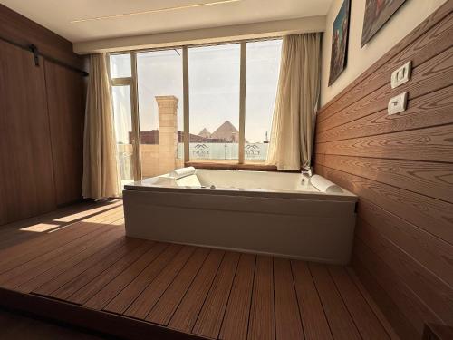 uma grande banheira num quarto com uma janela em The Palace Pyramids Hotel no Cairo