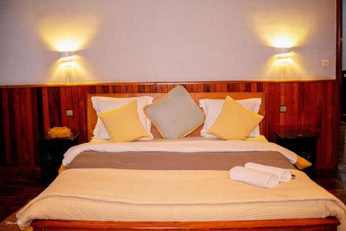 a large bed in a room with two lights on the wall at L'anis Etoilé in Antsirabe