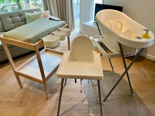 a high chair and a high table in a living room at Kindvriendelijk sfeervol vakantiehuis Bosgeneugte bij zwembad op de Veluwe in Doornspijk