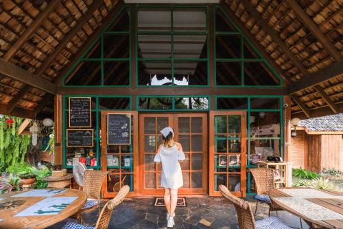 a woman in a white dress standing in front of a restaurant at Ban MaeBo Local Stay in Ban Nong Han