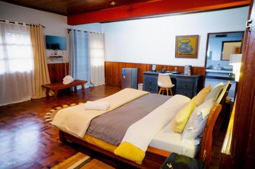 a bedroom with a large bed and a desk at L'anis Etoilé in Antsirabe