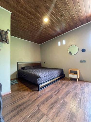 a bedroom with a bed and a wooden floor at Villa Sibolangit Satu Hati near Hillpark with private pool in Bandarbaru