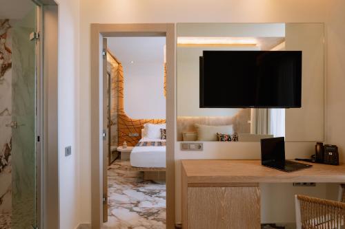 a hotel room with a bed and a desk with a television at ZEST THASSOS LUXURY RETREAT in Limenaria