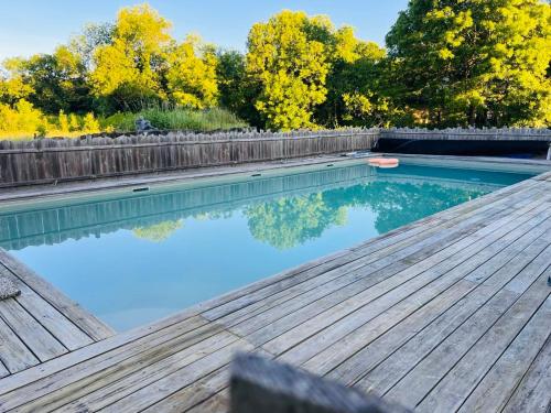 - une piscine avec une terrasse en bois et de l'eau bleue dans l'établissement Cottage au bord de l eau, à Macau