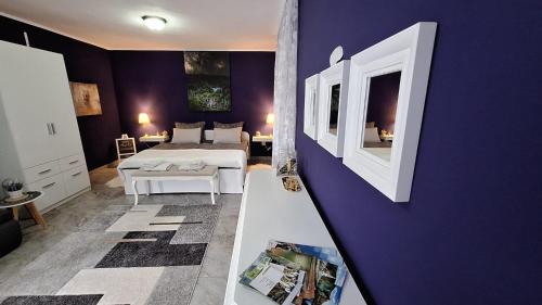 - une chambre avec un lit et un mur violet dans l'établissement Studio apartman Marta, à Korenica