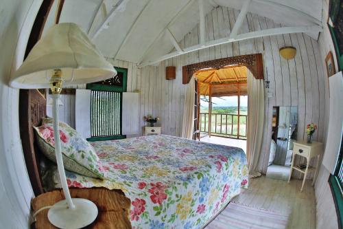 una camera da letto con un letto con una lampada e una finestra di Mukima Manor a Nanyuki