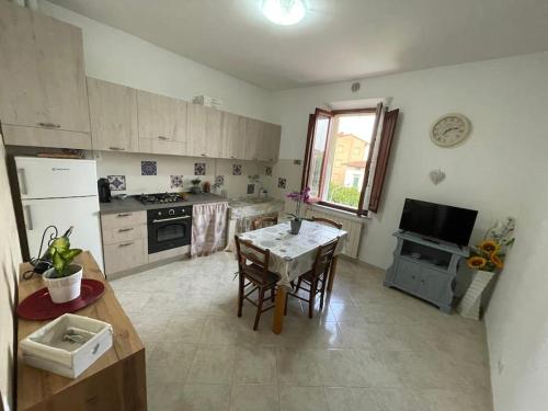 cocina con mesa, mesa pequeña y sillas en La Casa di Alex - Alex's House, en Colle Val D'Elsa