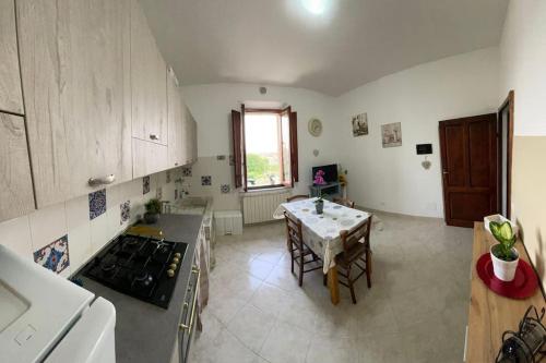 una cocina con una mesa y una estufa horno superior en La Casa di Alex - Alex's House, en Colle Val D'Elsa