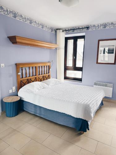 une chambre avec un grand lit et une fenêtre dans l'établissement Le Régis, à Laguiole