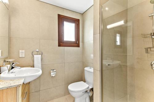 a bathroom with a toilet and a sink and a shower at Apartment Theia with sea and sunset views, the Resort in Aphrodite Hills in Kouklia