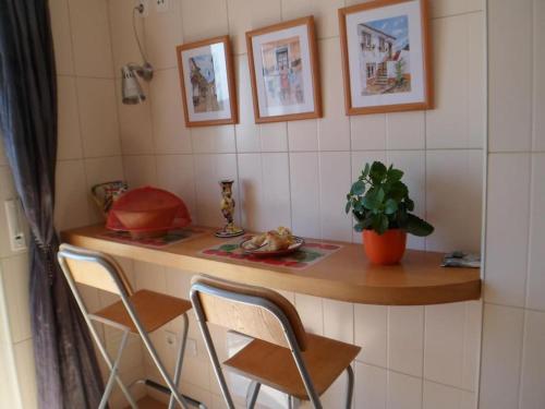 un mostrador con 2 sillas y una mesa con una planta en Ferienwohnung Meerblick Atalaia, en Lourinhã