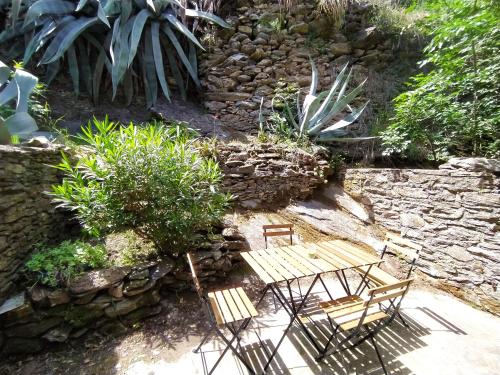 a patio with two benches and a stone wall at Sole e Ventu in Velone-Orneto