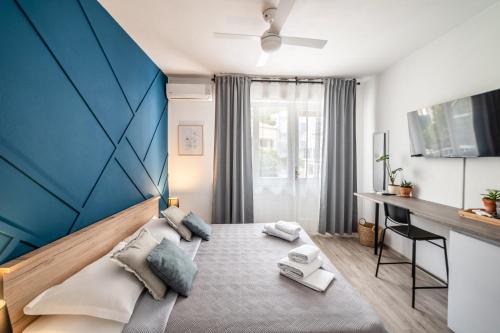 1 dormitorio con 1 cama con pared azul en Wind Rose Rooms en Baška Voda