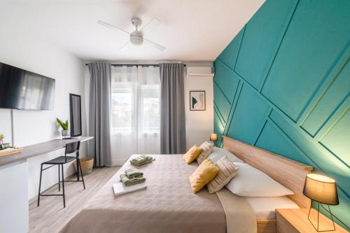 1 dormitorio con cama y pared azul en Wind Rose Rooms en Baška Voda