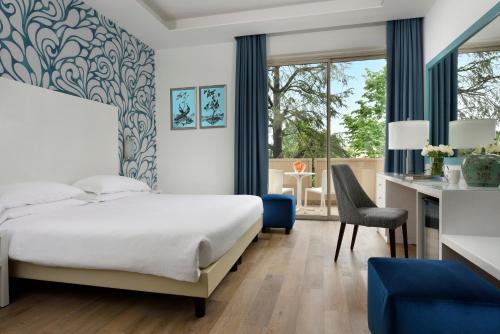 una camera con letto e scrivania di Hotel Continental Wellness & Spa a Sirmione