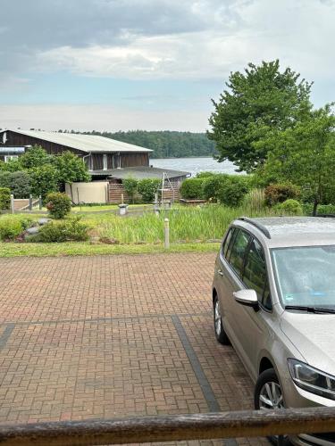 a car parked in a parking lot next to a house at Einraumapartment im Erdgeschoss mit Seeblick in Rheinsberg