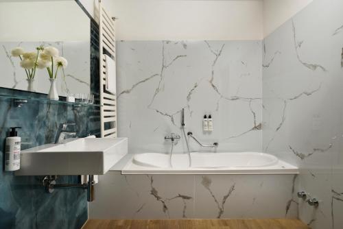 ein Badezimmer mit einer weißen Badewanne und einem Waschbecken in der Unterkunft Hotel Continental Wellness & Spa in Sirmione