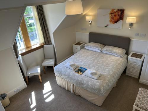una camera da letto con un letto e due asciugamani di Corunna Bed & Breakfast and Garden Cottage a Inverness