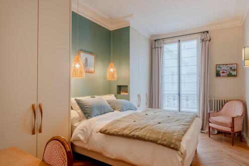 une chambre avec un grand lit et une fenêtre dans l'établissement Paris Wagram Design Residence, à Paris