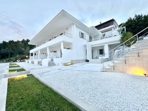 a white house with stairs and grass in front at Petra Maris B&B in Peschici