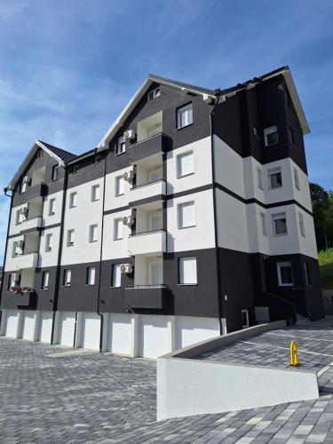 a large apartment building with a black and white facade at Apartman WIN Sokobanja in Soko Banja