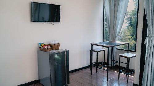 a room with two stools and a television on the wall at Finca Hotel Los Alpes in Manizales