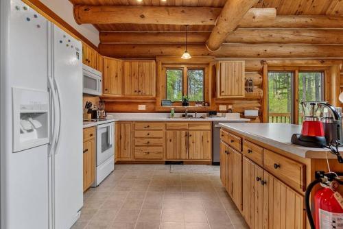 a kitchen with wooden cabinets and a white refrigerator at Peaceful Valley Hideaway in Rapid City
