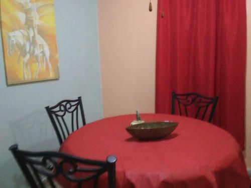 a red table with a bowl on top of it at Brisas de Borinquen in Aguadilla