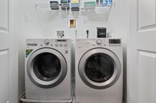 two washing machines are in a white laundry room at New Tropical Island Oasis in Baltimore