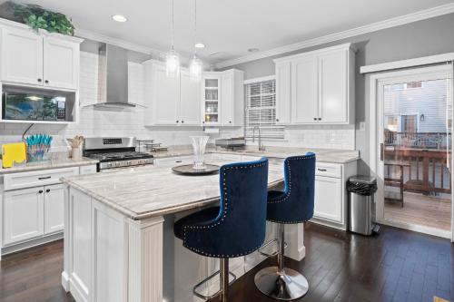 a kitchen with white cabinets and blue bar stools at New Tropical Island Oasis in Baltimore
