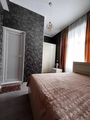 a bedroom with a large bed and a window at Guesthouse Turo in Ambrolauri