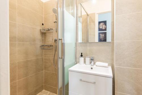 Un baño con ducha, inodoro y lavabo. en Geranimus Court of Scents, en Versalles